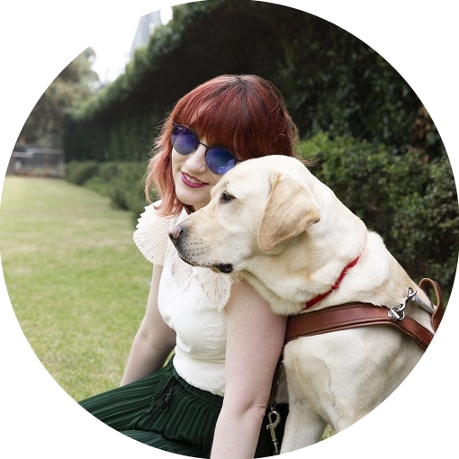 Image shows young girl resting her head on the head of her Guide Dog who is sitting next to her in a harness. Image shows young girl resting her head on the head of her Guide Dog who is sitting next to her in a harness.